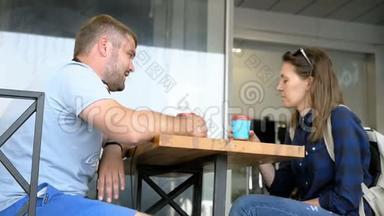 年轻夫妇正在喝着蓝色杯子的咖啡，<strong>聊天</strong>可爱。 闲的<strong>爱心</strong>人士..